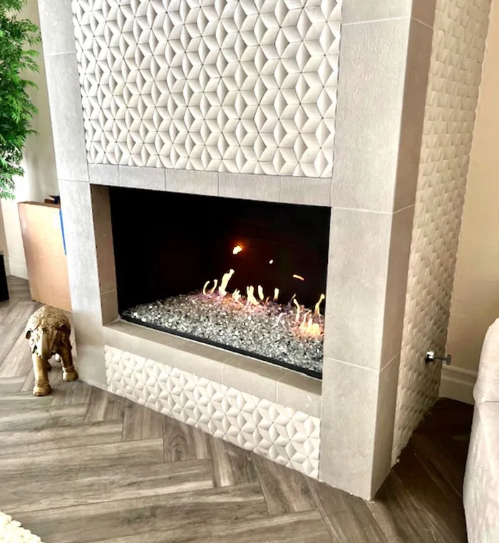 Silver reflective fire glass in a fireplace with white pillow tile